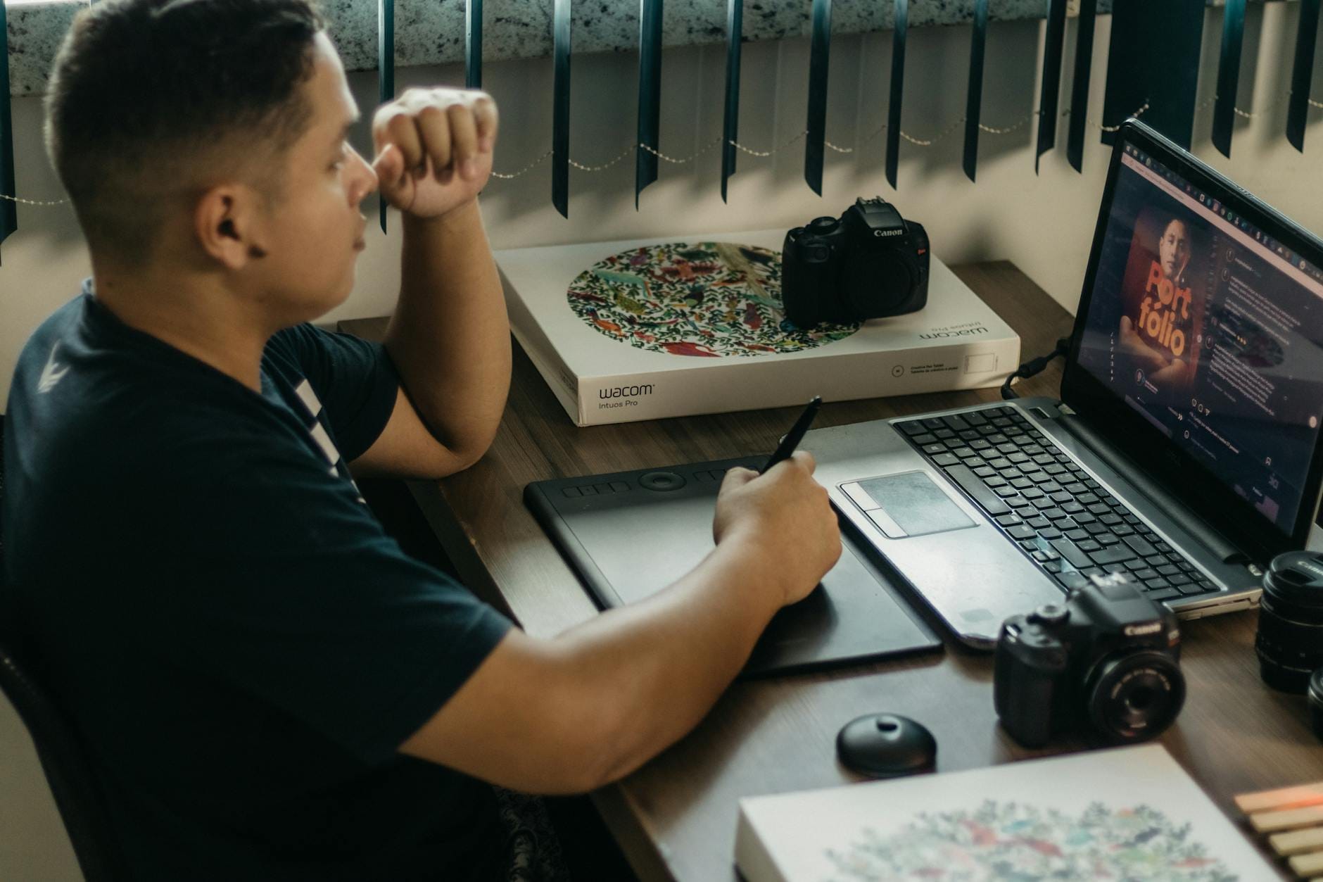 Uczeń edytuje zdjęcia na laptopie i tablecie graficznym przy biurku